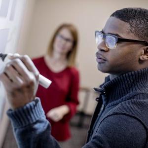 Montevallo student working on a whiteboard.